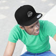 Load image into Gallery viewer, Person wearing Saltbox Brewing Company unisex flat bill hat in black and green