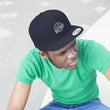 Load image into Gallery viewer, Person wearing Saltbox Brewing Company unisex flat bill hat in true navy and green