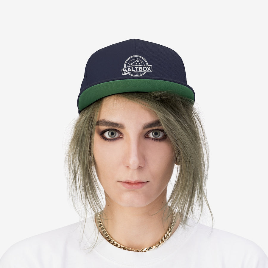 Person wearing Saltbox Brewing Company unisex flat bill hat in true navy and green