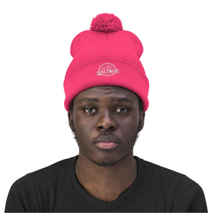 Man with neon pink Saltbox pom pom beanie on head
